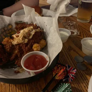 a basket of fried chicken with a side of ketchup