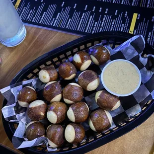 a basket of pretzels with dipping sauce