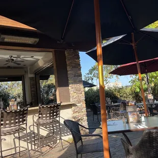 tables and chairs with umbrellas