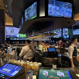 people at a bar with a lot of tv screens