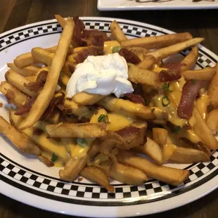 a plate of fries with cheese and bacon