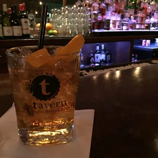 a tall glass with a drink on the bar