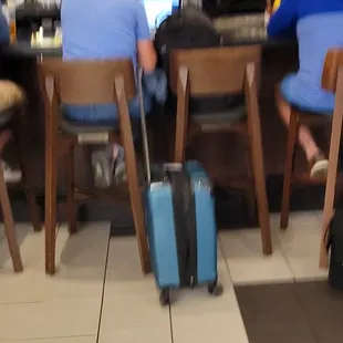 people sitting at the bar with their luggage