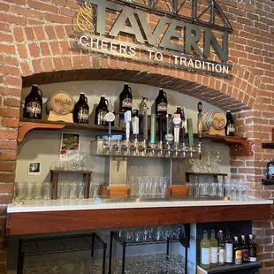 a brick wall with a sign above the bar