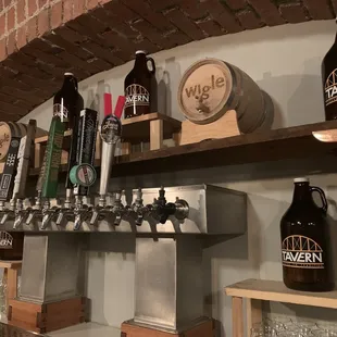 a row of beer taps on a brick wall