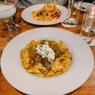 a plate of pasta with mushrooms and sour cream