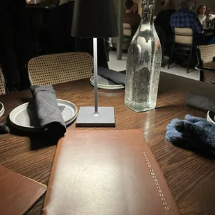 a table with a menu and a bottle of wine