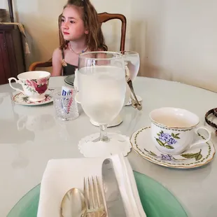 a little girl sitting at a table