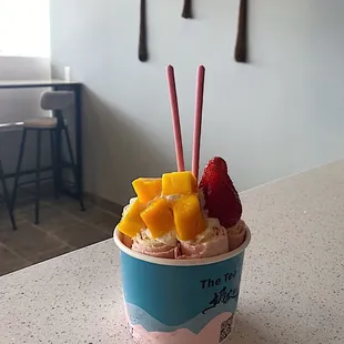 a cup of ice cream with fruit on top