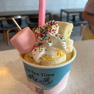 a cup of ice cream with sprinkles and marshmallows