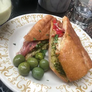 a sandwich and olives on a plate