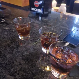 two glasses of alcohol on a bar