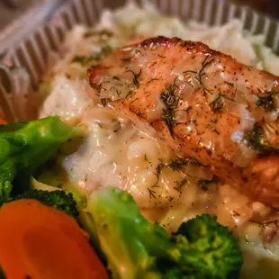 Salmon over potatoes with steamed vegetables.