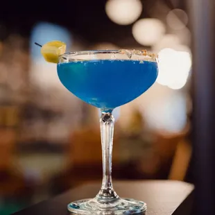 a blue cocktail in a glass