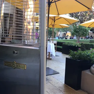 a patio with a grill and umbrellas