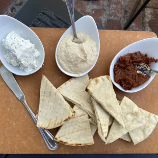 Trio of spreads: herbed goat cheese, hummus, sun dried tomatoes, with pita bread