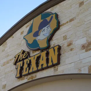  the texan logo on a brick building