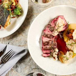 two plates of food and a glass of wine
