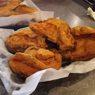 Four pieces of fried chicken breast and their potatoe wedges.