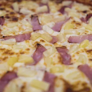 a pizza with pineapples and ham