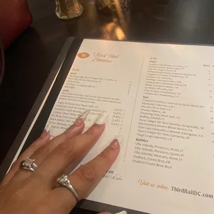 a woman's hand on a menu