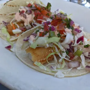 two fish tacos on a white plate