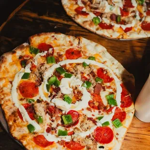 two pizzas on a wooden table
