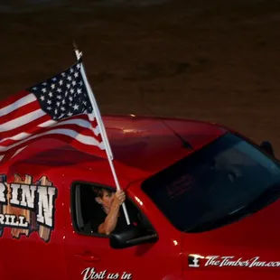 a red truck with an american flag on top