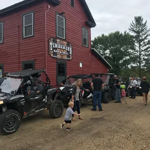 a group of people standing in front of a red building