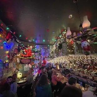 a crowded bar with christmas lights