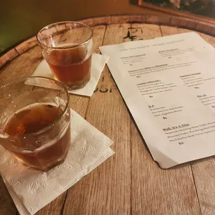 two glasses of beer and a menu
