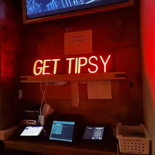 a neon sign that reads get tipsy