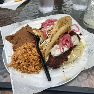 Blackened fish tacos with rice and refried beans.