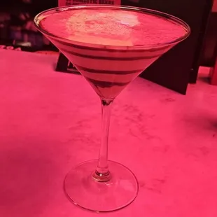 a pink cocktail in a martini glass