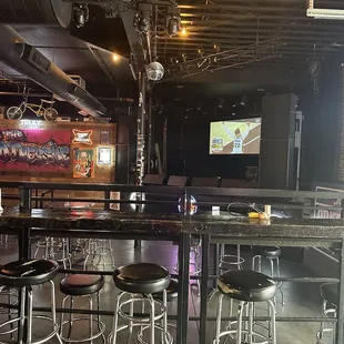 a bar with stools and a television