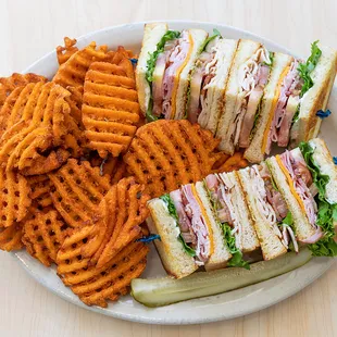 a plate of sandwiches and waffle fries