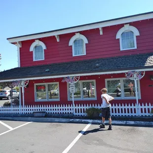 a man standing in front of a red building