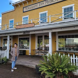 a woman standing in front of a yellow building