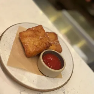 a plate of fried food with ketchup