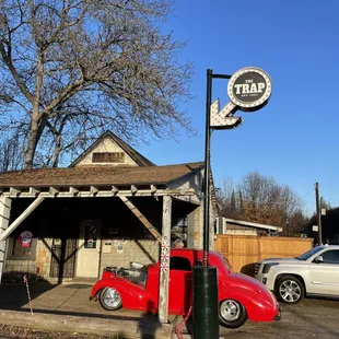 a red car parked in front of a gas station