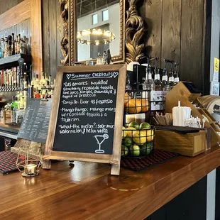 a bar with a chalkboard sign on the counter