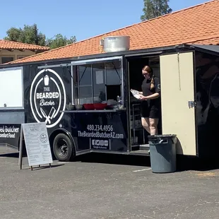 a woman standing in the doorway of a food truck