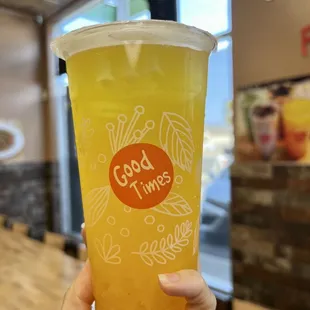 a person holding a cup of orange juice