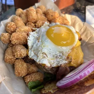 a burger with fried eggs and bacon