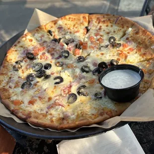 a pizza with olives and cheese