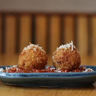 two deep fried meatballs on a plate