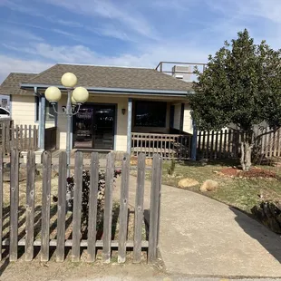 a house with a fence and a street sign