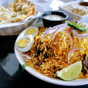 Kolkata Style Mutton Biryani: basmati rice, goat pieces, boiled egg, potato chunk, ghee, mawa, saffron milk, spices, meetha attar ($23.99).