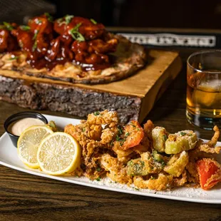 a plate of fried food and a glass of whiskey