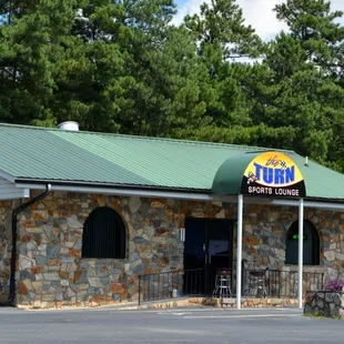 a stone building with a green roof